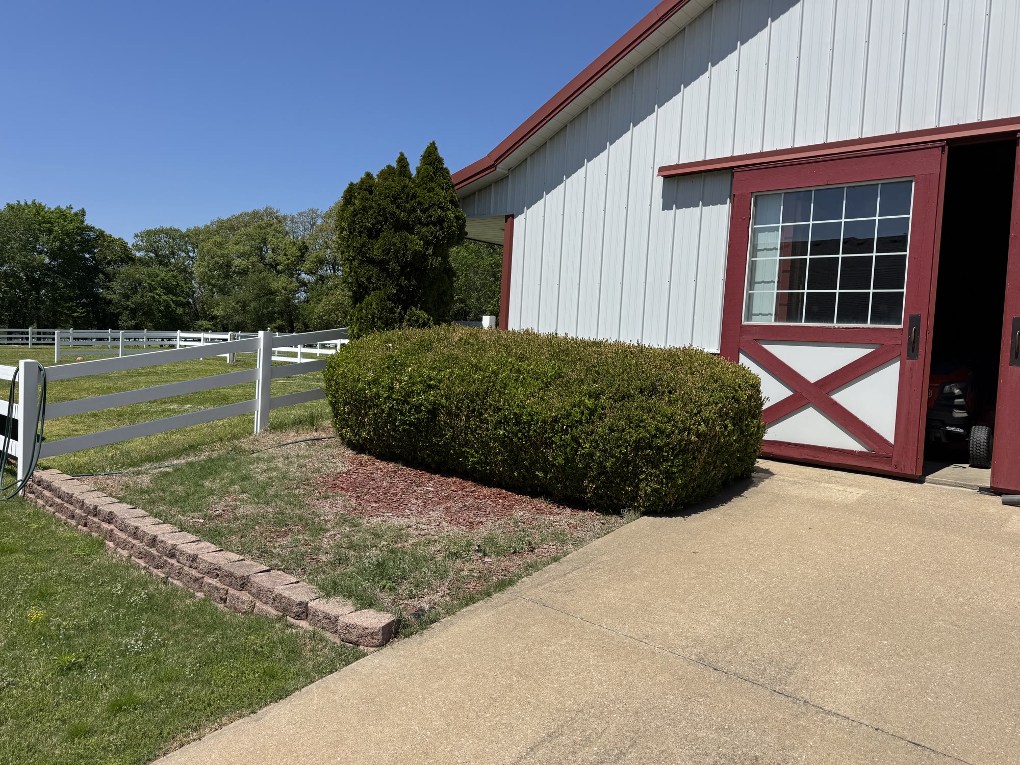 Outbuilding landscape bed before maintenance