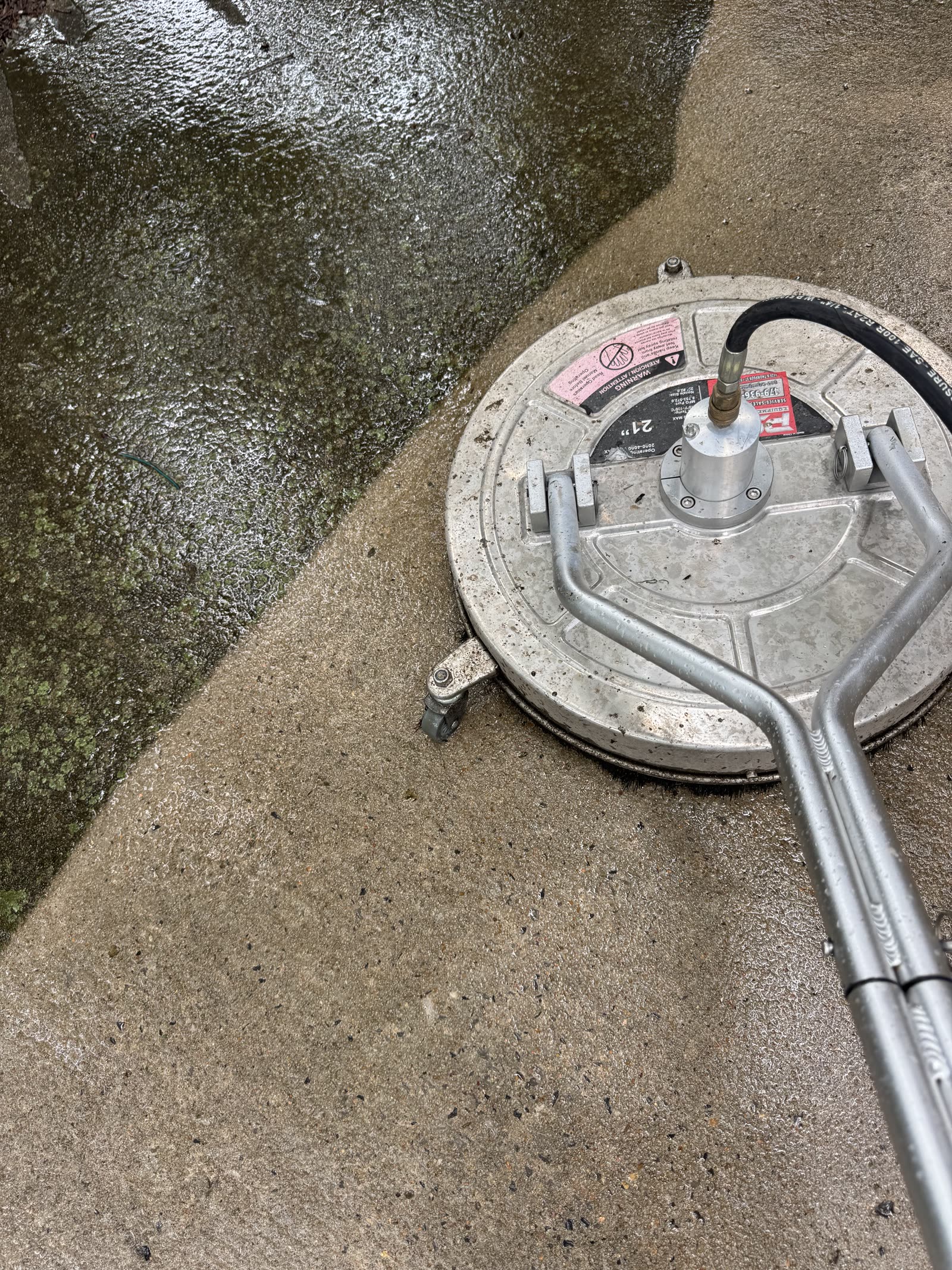 Professional surface cleaner pressure washing a concrete walkway